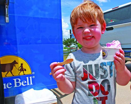 Monitor Photo/Carla Gray Cam Newkirk could not resist a big scoop of strawberry Blue Bell Ice Cream from the Blue Bell Lone Star Scoop Tour July 14.