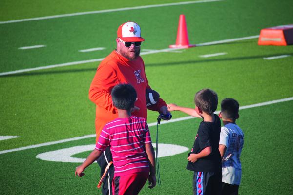 Monitor Photo/Russell Slaton Kemp High School assistant football coach Jamie Martin rounds up summer football clinic attendees during the last week of the event.